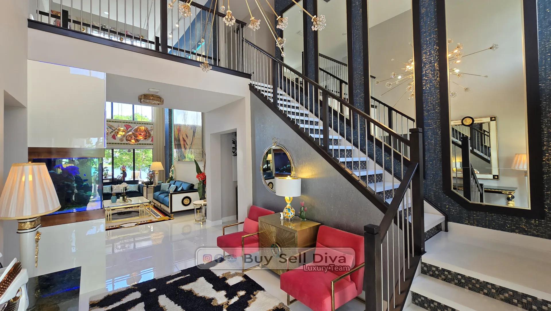Parkland FL estate home grand foyer with floating staircase, mirrored walls, and crystal chandelier